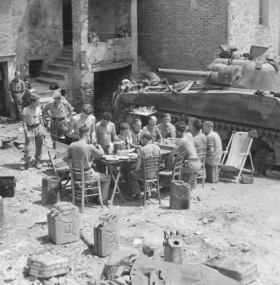 Number 1 troop, commanded by Lieutenant Murray Maidlow (Mimico, ON), enjoys a meal in style on the outskirks of Pucciarelli. DND/Library and Archives Canada/PA-145776.